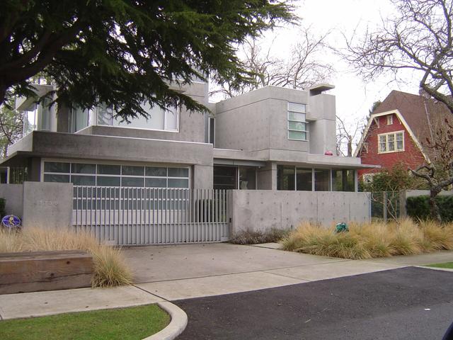 Modern house with a pale exposed aggregate driveway and front garden