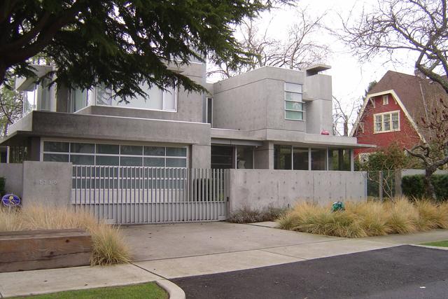 Modern house with a pale exposed aggregate driveway and front garden